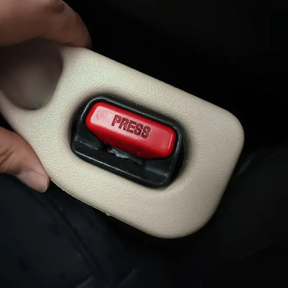 תקריב של אביזר אטם בצבע בז' המותקן סביב תושבת חגורת הבטיחות ברכב. ניתן לראות את כפתור ה־PRESS האדום, כשהאטם מותאם במדויק למבנה